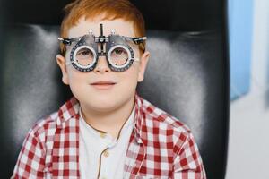 ein Junge im Brille prüft Auge Vision beim Augenarzt. foto