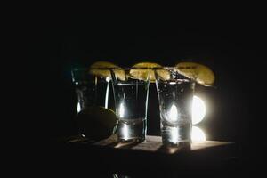 Tequila mit Limette und Salz- auf schwarz Hintergrund foto