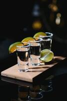 Tequila mit Limette und Salz- auf schwarz Hintergrund foto