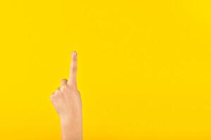 Kinder- Hand mit ein angehoben Index Finger. Beachtung Zeichen oder Idee. Erste, eins, gerichtet Geste foto