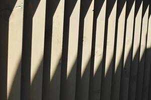 hölzern braun Vertikale dunkel Lamellen, Bretter mit ein hell Streifen von das Sonne. Fertigstellung Element. abstrakt Hintergrund. foto