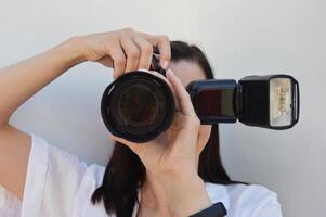 ein Frau Fotograf hält ein Kamera im ihr Hände und nimmt Bilder. Nahansicht Schuss. foto