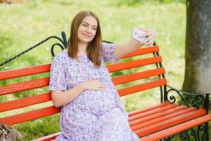 schwanger Frau ruhen im das Park foto