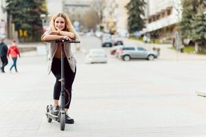 Mädchen im elektrisch Roller Reiten im das alt Stadt Center foto
