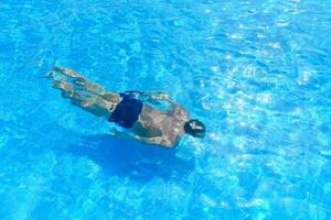 Fachmann Schwimmer unter Wasser nach das springen foto