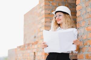 Frauen Ingenieur aussehen beim Gebäude Glas. foto