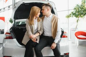 jung schön glücklich Paar Kauf ein Wagen. Mann Kauf Auto zum seine Ehefrau im ein Salon. Auto Einkaufen Konzept foto