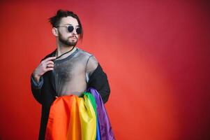 glücklich Fröhlich Mann haben Spaß halten Regenbogen Flagge Symbol von lgbtq Gemeinschaft foto