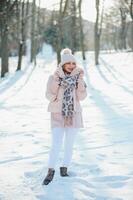 schönes Winterporträt der jungen Frau in der schneebedeckten Winterlandschaft foto