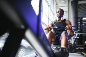 afrikanisch amerikanisch Mann Arbeiten aus im das Fitnessstudio. foto