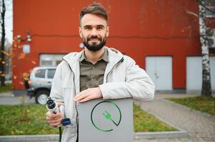 Mann Hand halten elektrisch Auto Ladegerät. elektrisch Fahrzeug ev Laden Bahnhof und Ladegerät. foto