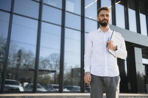 Fachmann Nachlass Verkäufer mit Zwischenablage Schreiben Unterlagen draußen im Vorderseite von gemietet Haus mit Werbung Bereich foto