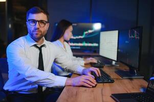 Mannschaft von Händler Arbeiten beim Monitor Computer und Surfen online im Handel Büro foto