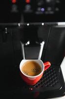 modern Espresso Kaffee Maschine mit ein Tasse im Küche foto