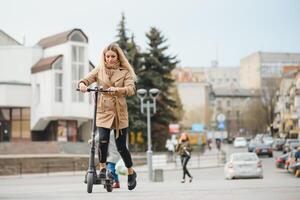 Mädchen im elektrisch Roller Reiten im das alt Stadt Center foto