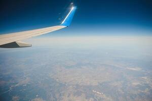 Wolken und Himmel durch das Fenster eines Flugzeugs gesehen foto