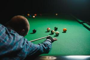 jung gut aussehend Mann gelehnt Über das Tabelle während spielen Snooker foto