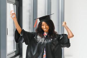 fröhliche afroamerikanische Doktorandin mit Diplom in der Hand foto