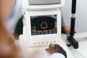 modern medizinisch Ausrüstung. schließen oben von Augenarzt mit Auto Refraktometer während Prüfung Kind Augen. foto