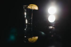 Tequila mit Limette auf ein dunkel Hintergrund foto