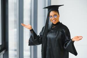 glücklich afrikanisch amerikanisch weiblich Schüler mit Diplom beim Abschluss foto