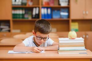 wenig Kind Schreiben mit bunt Bleistifte, drinnen. elementar Schule und Bildung. Kind Lernen Schreiben Briefe und Zahlen. foto