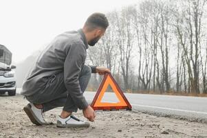 traurig Treiber haben Motor Problem Stehen in der Nähe von gebrochen Auto auf das Straße. Auto Nervenzusammenbruch Konzept foto