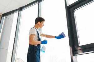 Reinigung Bedienung kam zu sauber Neu Haus. hart arbeitend Mann vorsichtig sauber Fenster. Seite Aussicht foto