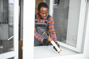 afrikanisch Bedienung Mann Installation Fenster foto