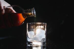 Whiskey Glas schwarz Hintergrund glänzend foto