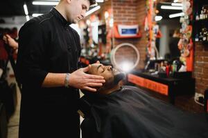 afrikanisch männlich Klient bekommen Haarschnitt beim Barbier Geschäft von Fachmann Friseur. foto