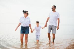 glückliche Familie, die am Strand spazieren geht foto