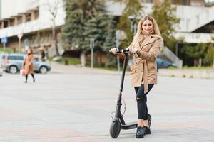 Mädchen im elektrisch Roller Reiten im das alt Stadt Center foto