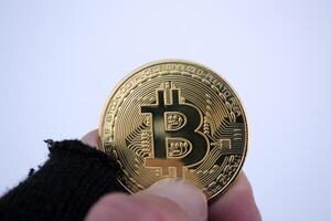 golden Bitcoin im männlich Hand. Gold Münze von Kryptowährung. foto