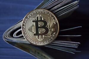 golden Bitcoin und Dollar im männlich Hand auf ein dunkel Blau hölzern Hintergrund. Gold Münze von Kryptowährung. foto