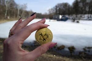 golden Bitcoin im weiblich Hand. ein Münze von Kryptowährung. foto