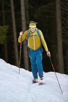 ein Mann Berg Skifahrer gehen bergauf foto