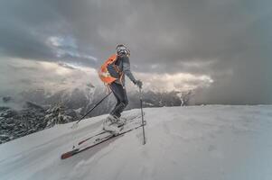 wenig Junge mit Bergsteigen Ski gehen bergauf foto