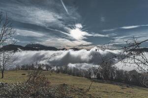 hügelig Landschaft mit Wiesen und Wolken foto