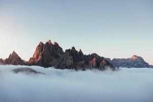 stell dir vor, du stehst da. die Gipfel der Berge ersticken vor dichtem Nebel. unglaubliche Fotoaufnahmen foto