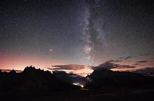 ruhiger und stimmungsvoller Ort. schöner raum voller sterne am himmel. die Berge sind von dichtem Nebel umgeben foto