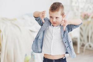 Junge deutet mit dem Finger nach unten. Emotion-Konzept. zeigt seine Einstellung zu Unterricht und Schule foto