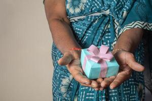 Nahansicht von Senior indisch Frau halten Geschenk Box im Hand foto