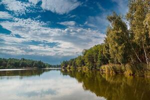 schön Aussicht von das See mit Blau Himmel, Wolken, und Grün Bäume foto