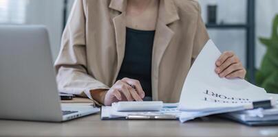 Geschäftsfrau mit Taschenrechner für Mathe-Finanzierung auf Holzschreibtisch im Büro- und Geschäftshintergrund, Steuern, Buchhaltung, Statistik und analytisches Forschungskonzept foto