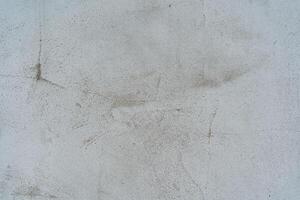 grau Mauer mit texturiert Oberfläche. Fußabdrücke auf das Mauer. Wasser Flecken auf das Oberfläche. texturiert Mauer. alt Mauer Abdeckung. Renovierung erforderlich foto