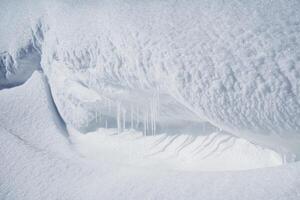 ein Schnee Drift von groß Größe. Eiszapfen Schmelze im das Sonne. ein Weiß aufblasbar Webstühle Über das Fluss. foto