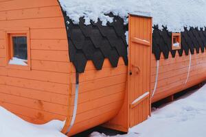 Sauna Fass steht auf das Straße Winter Gemälde Tür zum das Eingang zu das Sauna hölzern Gebäude zum Hitze Dampf Zimmer foto