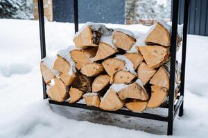 schließen Schuss von Protokolle. gehackt Birke Brennholz im ein Protokoll. gestapelt Brennholz im das Hinterhof. Brennholz unter das Schnee. bauen ein Feuer, Hitze ein Sauna und ein Kamin foto