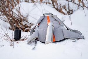 bereiten das Lager zum ein Picknick im Winter. Tourist Geschirr gemacht von Metall. Thermosflasche, Becher, Rucksack. foto